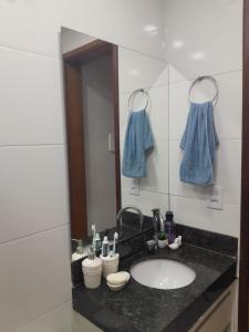 een badkamer met een wastafel en een spiegel bij Quarto próximo Av JK in Patos de Minas