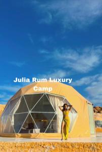 uma mulher em pé em frente a uma tenda em Julia Rum Luxury Camp em Wadi Rum