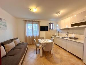 a kitchen and living room with a couch and a table at Bijela Apartment in Bijela