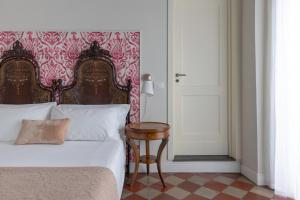 1 dormitorio con cama, mesa y puerta en Viva Catania, en Catania