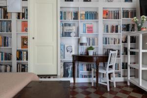Habitación con escritorio y estanterías llenas de libros. en Viva Catania, en Catania