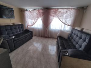 una sala de estar con 2 sofás y una ventana en Cabaña Turistica Tunwacogua, en Nobsa