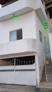 een wit gebouw met een poort en een garage bij Suíte itaporanga in Santa Maria Madalena