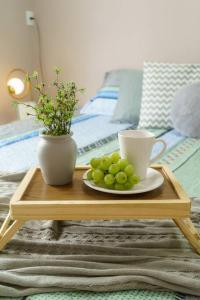 a table with a plate of grapes and cups on it at O Recanto M&M na Praia de Fora. in Palhoça