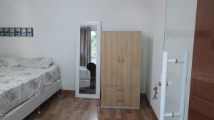 een slaapkamer met een bed en een houten kast bij Suíte itaporanga in Santa Maria Madalena +3 foto's