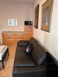 sala de estar con sofá de cuero marrón en Hotel Apartment, en Colonia