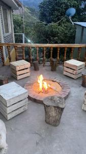 a fire pit sitting on a patio with logs at Finca Santa Lucia, Anolaima in Anolaima