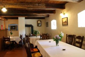 a dining room with tables and chairs and a vase of flowers at Kremenisko II in Banská Štiavnica