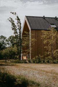 drewniana stodoła z czarnym dachem w obiekcie Domki Ulkowo w mieście Słajszewo