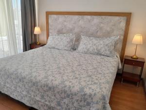 a bedroom with a bed with a floral bedspread and two lamps at Terraza Santa Lucia,Suites "Como en su Casa" in Santiago