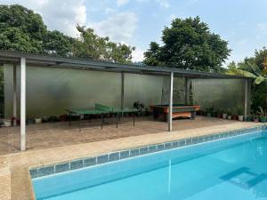 a patio with two ping pong tables next to a pool at Finca Santa Lucia, Anolaima in Anolaima