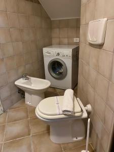 a bathroom with a toilet and a washing machine at Casa Bellavista in Nebida