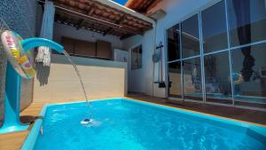 uma piscina com uma fonte de água numa casa em Casa de praia completa e confort em Barra de Santo Antônio