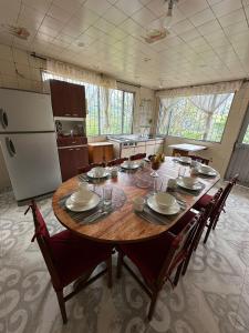uma cozinha com uma grande mesa de madeira com cadeiras e um frigorífico em Finca Santa Lucia, Anolaima em Anolaima