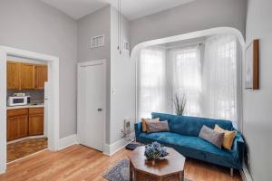 費城的住宿－Cozy, Charming 1-bdrm - University City，客厅配有蓝色的沙发和桌子