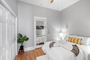 ein weißes Schlafzimmer mit einem Bett mit einer Schleife darauf in der Unterkunft Cozy, Charming 1-bdrm - University City in Philadelphia