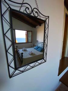 a mirror on a wall with a bed in a room at Casa Bellavista in Nebida