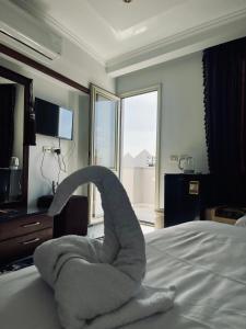 un animal de toallas sentado en una cama en una habitación de hotel en NEW ASSER HOTEL PYRAMID en El Cairo