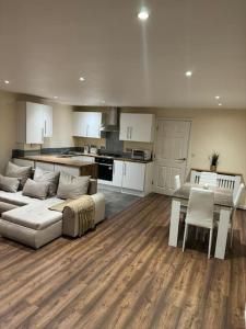 sala de estar con sofá, mesa y cocina en 2 Bedroom London Apartment, en South Norwood