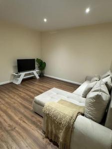 sala de estar con sofá y TV de pantalla plana en 2 Bedroom London Apartment, en South Norwood