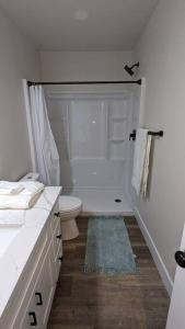 uma casa de banho branca com um WC e um chuveiro em 1BR ADU Retreat in Fresno em Fresno
