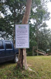 un cartel en un árbol al lado de un camión en CABAÑAS CEYTAKS, 