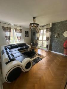 ein Wohnzimmer mit einem schwarz-weißen Sofa in der Unterkunft Appartement spacieux et calme in La Mulatière