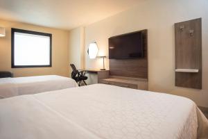 グアダラハラにあるホリデイ イン エクスプレス グアダラハラ イテソのベッド2台、薄型テレビが備わるホテルルームです。
