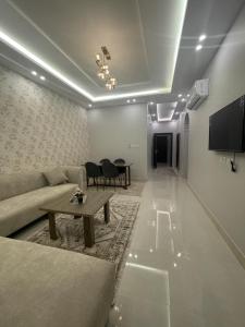 a living room with a couch and a table at شقق فندقيه فاخره بتصمم عصري ودخول ذاتي in Jeddah