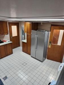 a kitchen with a stainless steel refrigerator and wooden cabinets at جناح خاص مطل على الحرم النبوي الشريف in Medina