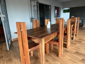 a wooden table with chairs and a wooden floor at Villa Melissa97-Bât5 lumineuse à Dzamandzar in Ambondrona +3 photos