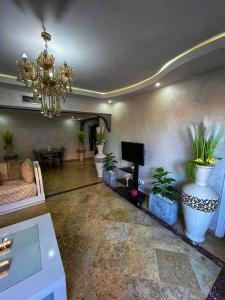 a living room with a chandelier and potted plants at Majorelle Garden Flat With Pool in Marrakesh