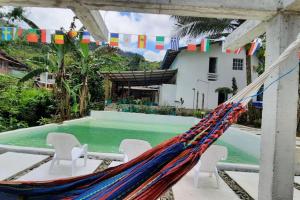 a hammock on a patio with a swimming pool at Chalet con Piscina cerca de: San Cipriano y las chorreras de Perico in Buenaventura