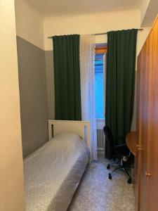 a bedroom with a bed and green curtains and a desk at Cozy apartment in graz in Graz
