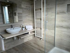 uma casa de banho com um lavatório e uma cabina de duche em vidro. em Villa INN em Villaperuccio