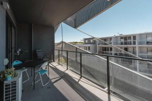 einen Balkon mit einem Tisch und Stühlen auf einem Gebäude in der Unterkunft Lonsdale St 1-Bed Unit with Study Area and Parking in Canberra