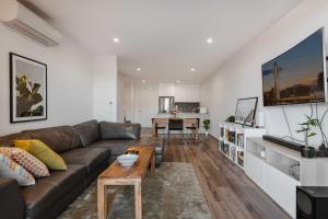 un soggiorno con divano e tavolo di Lonsdale St 1-Bed Unit with Study Area and Parking a Canberra