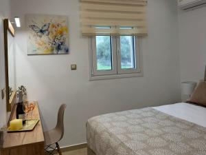 una camera con letto, scrivania e finestra di Paul’s Garden Luxury House a Haraki