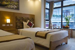 een hotelkamer met 2 bedden en een raam bij Sapa Snow Hotel in Sa Pa