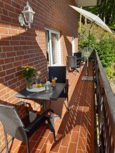 een patio met een tafel en stoelen en een parasol bij Ferienhaus Aanthuus in Brilon