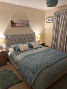 a bedroom with a large bed with a headboard at Beach House Walk - Crail - Home from Home in Crail