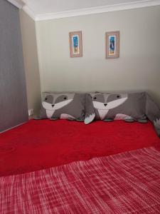 two pillows on a bed with a red blanket at Entire guesthouse walking to beach in Rosebud