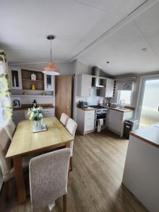 a kitchen and living room with a table and chairs at Dees hot tub breaks at Tattershall Lakes Jet Ski 4 in Tattershall