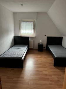 two beds in a room with a window at Schöne Wohnung mit TV, WLAN und Küche - Anna in Werne an der Lippe