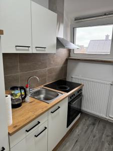 a kitchen with white cabinets and a sink and a window at Schöne Wohnung mit TV, WLAN und Küche - Anna in Werne an der Lippe