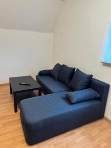 a living room with a blue couch and a table at Schöne Wohnung mit TV, WLAN und Küche - Anna in Werne an der Lippe
