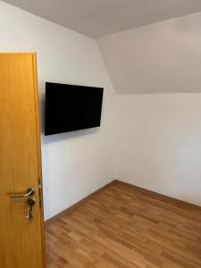 a room with a flat screen tv on a wall at Schöne Wohnung mit TV, WLAN und Küche - Anna in Werne an der Lippe