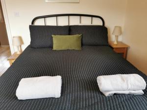 a bedroom with a bed with two towels on it at Unbeatable Llanberis Location, Detached with Parking, Snowdon Views. in Llanberis
