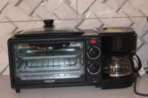 a toaster oven with a coffee maker on top of it at Bel appartement F2 Thies in Thiès