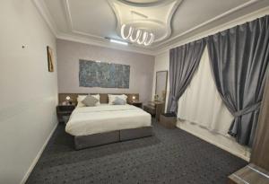 a bedroom with a bed and a large window at استيديو حياة الفيصلية دخول وخدمة ذاتيه in Ar Rass